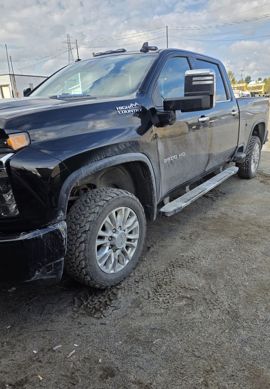 Black Chevrolet Silverado HD before detailing, body and wheels covered in road grime