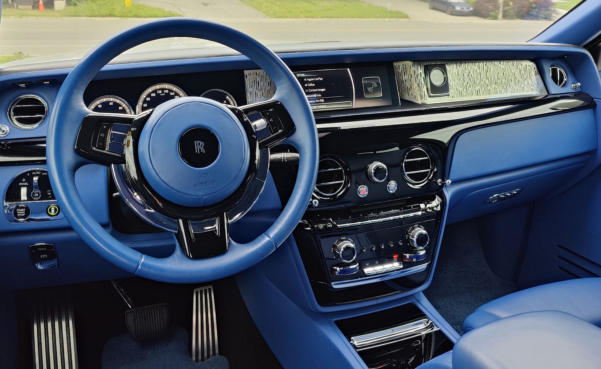 The blue leather interior of a Rolls-Royce Phantom I detailed: steering wheel, dashboard and centre console